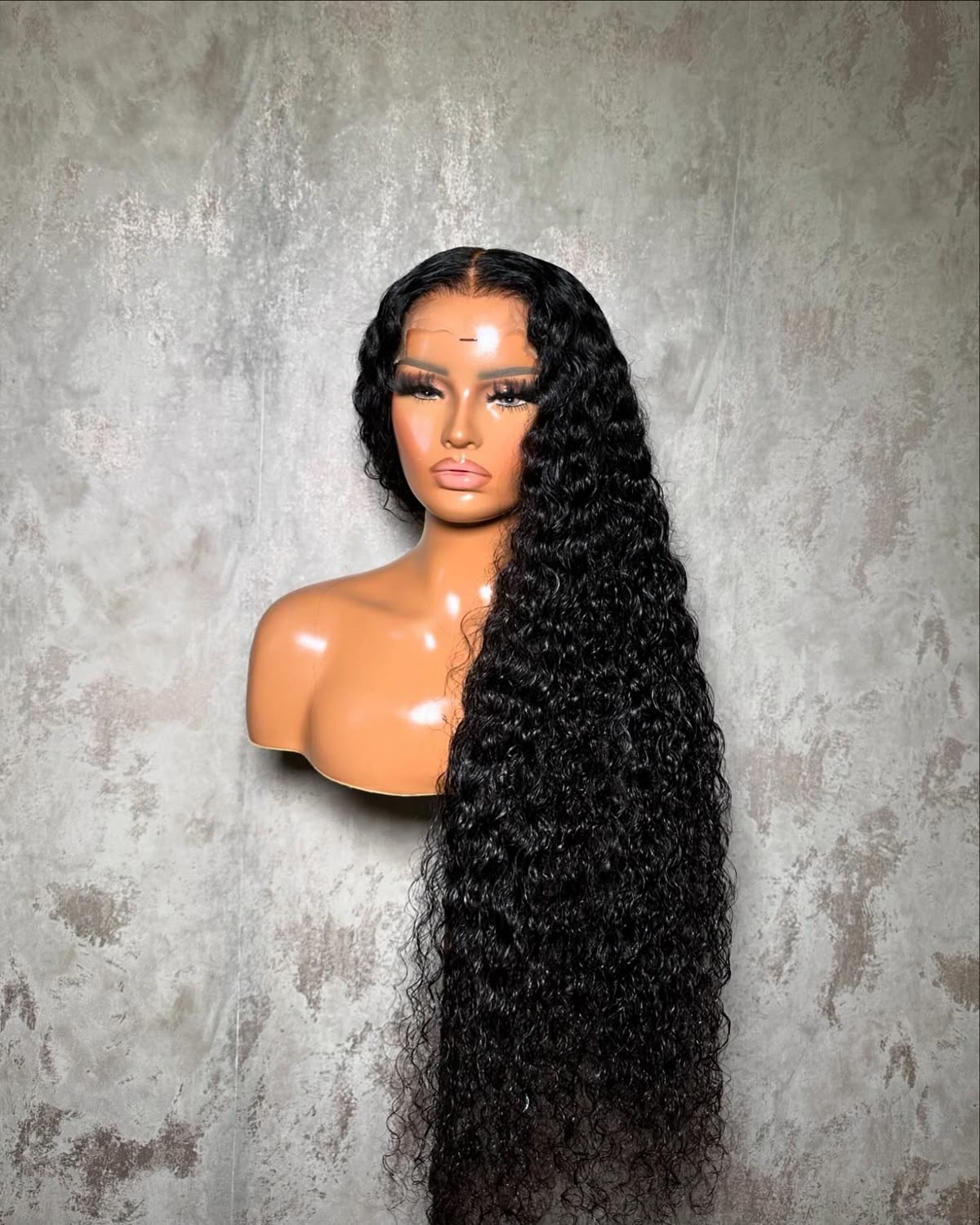 Long curly natural-black lace wig on display